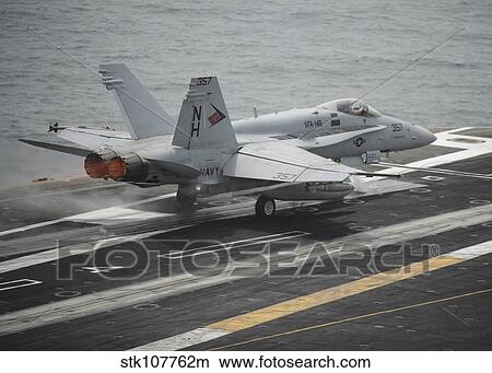An F/A-18C Hornet launches from the aircraft carrier USS Nimitz. View Large Photo Image Picture - An F/A-18C Hornet launches from the aircraft carrier USS Nimitz.. Fotosearch