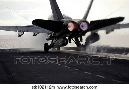 An F/A-18C Hornet rockets down the flight deck of USS Ronald Reagan. View Large Photo Image Picture - An F/A-18C Hornet rockets down the flight deck of USS Ronald Reagan.. Fotosearch