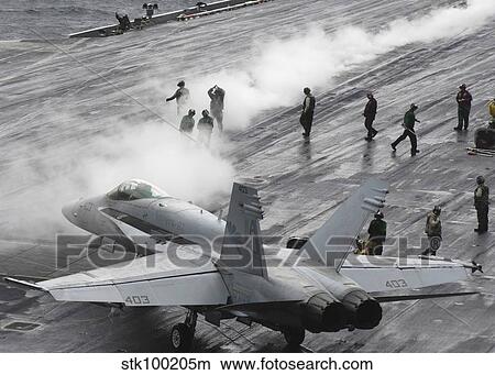 An F/A-18C Hornet taxies to a steam-powered catapult on the flight deck of USS Theodore Roosevelt. View Large Photo Image Picture - An F/A-18C Hornet taxies to a steam-powered catapult on the flight deck of USS Theodore Roosevelt.. Fotosearch