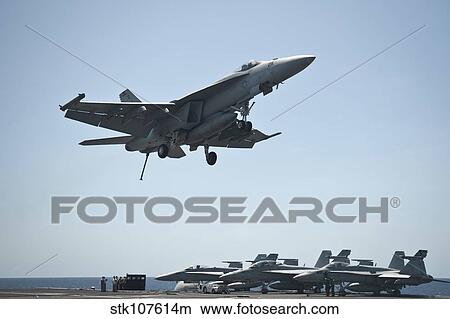 Picture - An F/A-18E Super Hornet flies over the flight deck of USS Nimitz.. Fotosearch