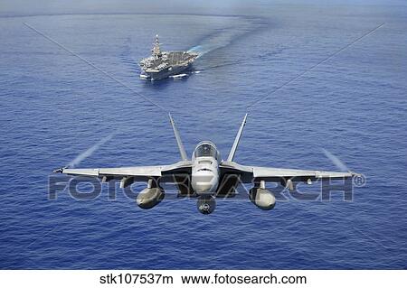 An F/A-18E Super Hornet flying above USS John C. Stennis. View Large Photo Image Picture - An F/A-18E Super Hornet flying above USS John C. Stennis.. Fotosearch