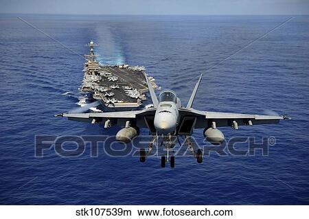 An F/A-18E Super Hornet flying above USS John C. Stennis. View Large Photo Image Picture - An F/A-18E Super Hornet flying above USS John C. Stennis.. Fotosearch