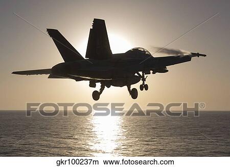 An F/A-18F Super Hornet takes off into the morning Sun over the Arabian Sea. View Large Photo Image Picture - An F/A-18F Super Hornet takes off into the morning Sun over the Arabian Sea.. Fotosearch