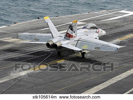 Picture - An F/A-18F Super Hornet traps an arresting wire on the flight deck of USS Abraham Lincoln.. Fotosearch