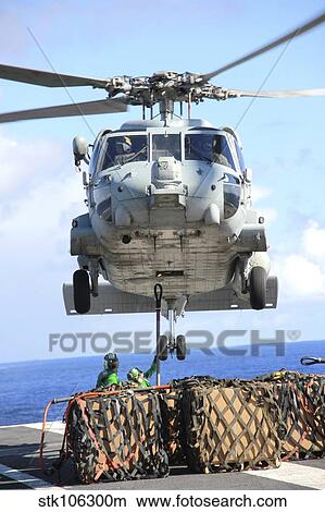An HH-60H Sea Hawk helicopter picks up supplies from the flight deck. View Large Photo Image Picture - An HH-60H Sea Hawk helicopter picks up supplies from the flight deck.. Fotosearch