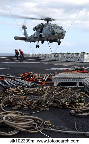 An HH-60H Seahawk helicopter prepares to lift a crate of ordnance. View Large Photo Image Picture - An HH-60H Seahawk helicopter prepares to lift a crate of ordnance.. Fotosearch