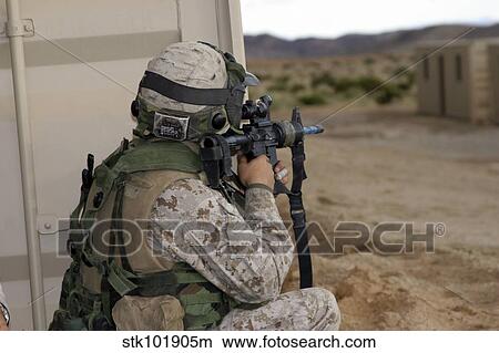 An infantry scout sights-in around the corner of a building. View Large Photo Image Picture - An infantry scout sights-in around the corner of a building.. Fotosearch