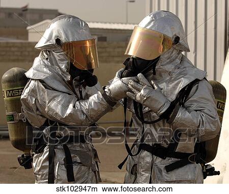 An Iraqi firefighter double checks his partner's personal protective equipment. View Large Photo Image Picture - An Iraqi firefighter double checks his partner's personal protective equipment.. Fotosearch