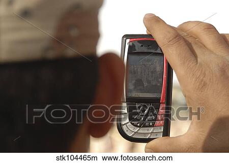 An Iraqi soldier records a change of command ceremony with his cell phone. View Large Photo Image Picture - An Iraqi soldier records a change of command ceremony with his cell phone.. Fotosearch