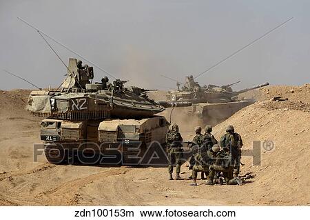 Picture - An Israel Defense Force Merkava Mark IV battle tank with infantry forces.. Fotosearch