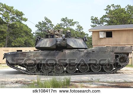 An M1A1 Abrams tank takes a defensive position on a simulated enemy town. View Large Photo Image Picture - An M1A1 Abrams tank takes a defensive position on a simulated enemy town.. Fotosearch