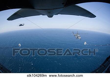 An MC-130P Combat Shadow prepares to refuel two HH-60G Pave Hawk helicopters. View Large Photo Image Picture - An MC-130P Combat Shadow prepares to refuel two HH-60G Pave Hawk helicopters.. Fotosearch