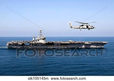 Picture - An MH-60R Sea Hawk flies near the Nimitz-class aircraft carrier USS John C. Stennis.. Fotosearch