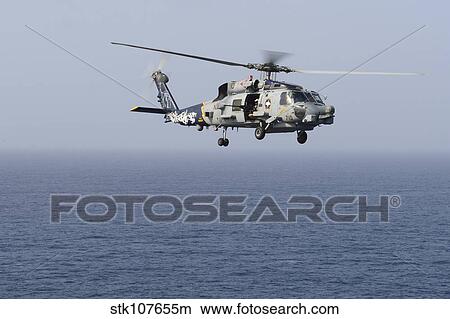 An MH-60R Sea Hawk helicopter flies over the Gulf of Oman. View Large Photo Image Picture - An MH-60R Sea Hawk helicopter flies over the Gulf of Oman.. Fotosearch