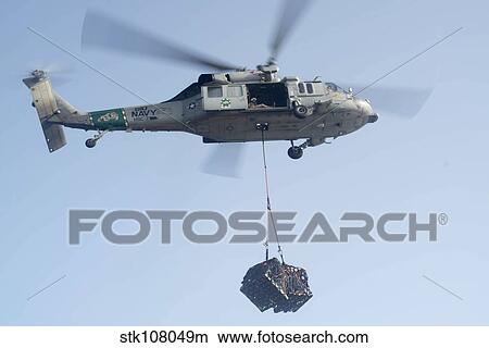 An MH-60S Knighthawk delivers cargo. View Large Photo Image Picture - An MH-60S Knighthawk delivers cargo.. Fotosearch