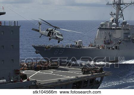 An MH-60S Knighthawk helicopter transports a pallet of supplies to USS Essex. View Large Photo Image Picture - An MH-60S Knighthawk helicopter transports a pallet of supplies to USS Essex.. Fotosearch