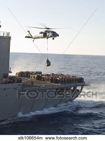 An MH-60S Sea Hawk helicopter carries supplies. View Large Photo Image Picture - An MH-60S Sea Hawk helicopter carries supplies.. Fotosearch