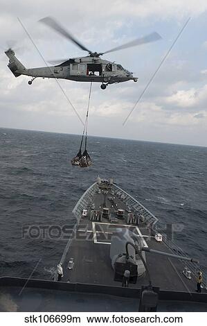 An MH-60S Sea Hawk helicopter delivers supplies to USS Mobile Bay. View Large Photo Image Picture - An MH-60S Sea Hawk helicopter delivers supplies to USS Mobile Bay.. Fotosearch