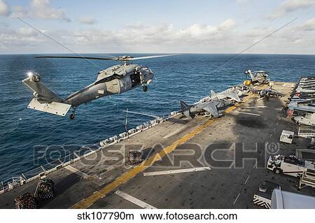 An MH-60S Sea Hawk helicopter delivers supplies to USS Bonhomme Richard. View Large Photo Image Picture - An MH-60S Sea Hawk helicopter delivers supplies to USS Bonhomme Richard.. Fotosearch