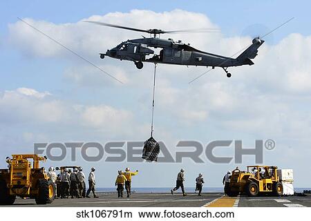 An MH-60S Sea Hawk helicopter lowers pallets of supplies onto USS Bonhomme Richard. View Large Photo Image Picture - An MH-60S Sea Hawk helicopter lowers pallets of supplies onto USS Bonhomme Richard.. Fotosearch