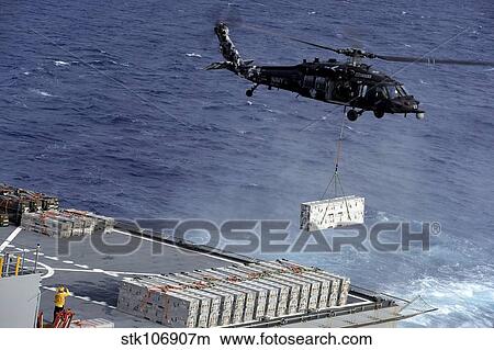 An MH-60S Sea Hawk helicopter picks up ammunition from USNS William McLean. View Large Photo Image Picture - An MH-60S Sea Hawk helicopter picks up ammunition from USNS William McLean.. Fotosearch