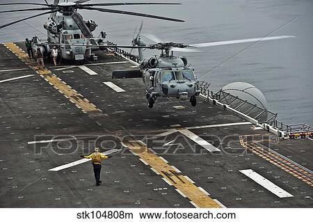An MH-60S Sea Hawk lands aboard the amphibious assault ship USS Makin Island. View Large Photo Image Picture - An MH-60S Sea Hawk lands aboard the amphibious assault ship USS Makin Island.. Fotosearch