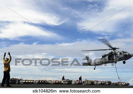 An MH-60S Sea Hawk lifts a pallet of ordnance from the aircraft carrier USS Ronald Reagan View Large Photo Image Picture - An MH-60S Sea Hawk lifts a pallet of ordnance from the aircraft carrier USS Ronald Reagan. Fotosearch