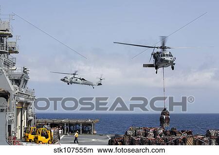 Picture - An MH-60S Sea Hawk picks up cargo from USNS Medgar Evers.. Fotosearch