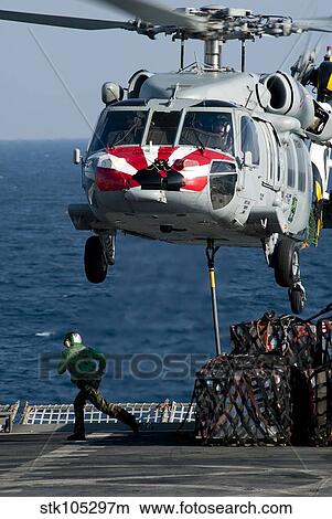 An MH-60S Sea Hawk picks up pallets from the flight deck of of USNS Rainier. View Large Photo Image Picture - An MH-60S Sea Hawk picks up pallets from the flight deck of of USNS Rainier.. Fotosearch