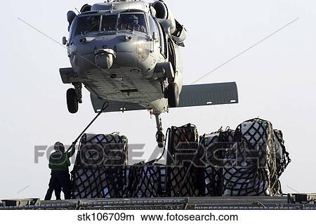 An MH-60S Sea Hawk picks up supplies from the flight deck of USNS Bridge. View Large Photo Image Picture - An MH-60S Sea Hawk picks up supplies from the flight deck of USNS Bridge.. Fotosearch