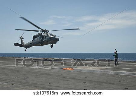 Picture - An MH-60S Sea Hawk prepares to land on the flight deck of USS Nimitz.. Fotosearch