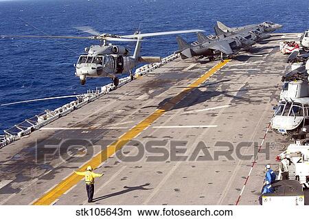 An MH-60S Seahawk helicopter prepares to land aboard USS Makin Island. View Large Photo Image Picture - An MH-60S Seahawk helicopter prepares to land aboard USS Makin Island.. Fotosearch