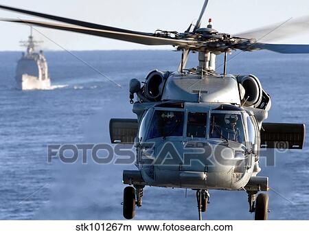 An MH-60S Seahawk helps conduct a vertical replenishment. View Large Photo Image Picture - An MH-60S Seahawk helps conduct a vertical replenishment.. Fotosearch
