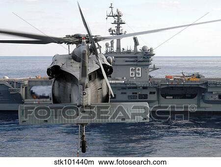 An MH-60S Seahawk hovers prior to taking a load of ammunition to USS Dwight D. Eisenhower. View Large Photo Image Picture - An MH-60S Seahawk hovers prior to taking a load of ammunition to USS Dwight D. Eisenhower.. Fotosearch
