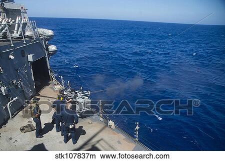 Picture - An MK-38 25mm machine gun is fired aboard USS Stout.. Fotosearch