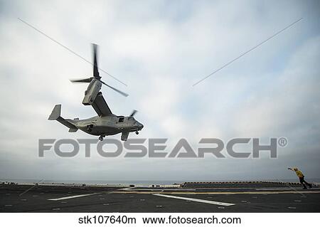 An MV-22 Osprey is guided onto the flight deck of USS Boxer. View Large Photo Image Picture - An MV-22 Osprey is guided onto the flight deck of USS Boxer.. Fotosearch
