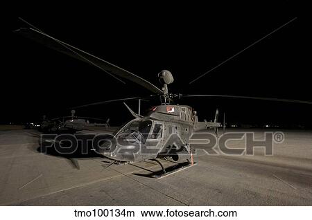 An OH-58D Kiowa sits on its pad at night. View Large Photo Image Picture - An OH-58D Kiowa sits on its pad at night.. Fotosearch