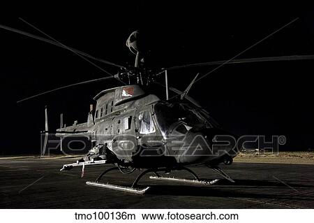 An OH-58D Kiowa sits on its pad at night. View Large Photo Image Picture - An OH-58D Kiowa sits on its pad at night.. Fotosearch