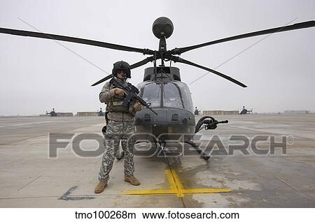 An OH-58D Kiowa Warrior pilot stands beside his aircraft. View Large Photo Image Picture - An OH-58D Kiowa Warrior pilot stands beside his aircraft.. Fotosearch