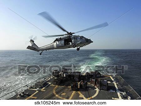An SH-60R Sea Hawk delivers pallets during a replenishment at sea. View Large Photo Image Picture - An SH-60R Sea Hawk delivers pallets during a replenishment at sea.. Fotosearch