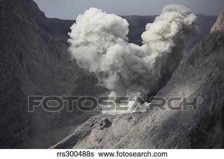 Stock Photograph - Ash cloud rises from crater of Batu Tara volcano, Indonesia.. Fotosearch