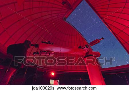 Astronomer makes observations through a large refractor telescope. View Large Photo Image Stock Photograph - Astronomer makes observations through a large refractor telescope.. Fotosearch