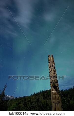 Stock Photograph - Aurora above totem pole. Fotosearch