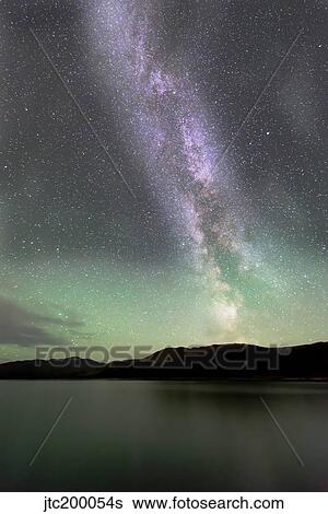 Stock Photograph - Aurora borealis and Milky Way above Fish Lake, Yukon, Canada.. Fotosearch