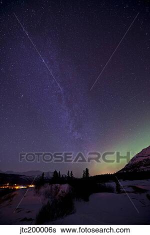 Stock Photograph - Aurora borealis and Milky Way over Carcross, Yukon, Canada.. Fotosearch
