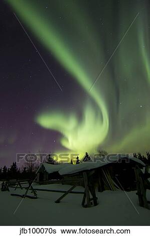 Aurora borealis and the Big Dipper above a log cabin at Whitehorse, Yukon, Canada. View Large Photo Image Stock Photograph - Aurora borealis and the Big Dipper above a log cabin at Whitehorse, Yukon, Canada.. Fotosearch
