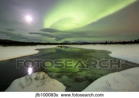 Aurora borealis over a creek by Fish Lake, Whitehorse, Yukon, Canada. View Large Photo Image Stock Photograph - Aurora borealis over a creek by Fish Lake, Whitehorse, Yukon, Canada.. Fotosearch