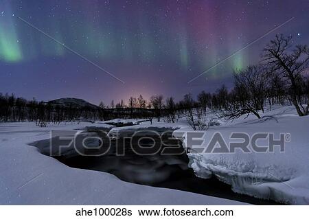 Stock Photograph - Aurora Borealis over Blafjellelva RIver in Troms County, Norway.. Fotosearch