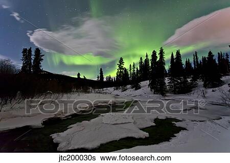 Stock Photograph - Aurora borealis over creek, Yukon, Canada.. Fotosearch