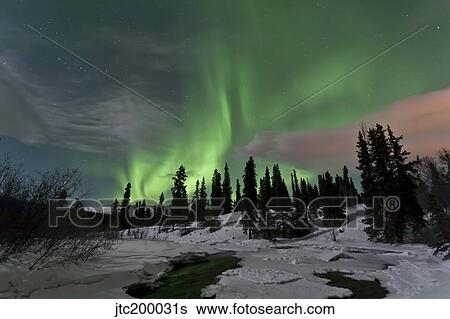 Stock Photograph - Aurora borealis over creek, Yukon, Canada.. Fotosearch